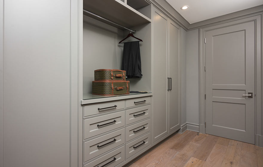 Floor to ceiling cabinetry in grey, provides a clean look, the simplicity of the room helps keep the focus on getting ready and out the door.