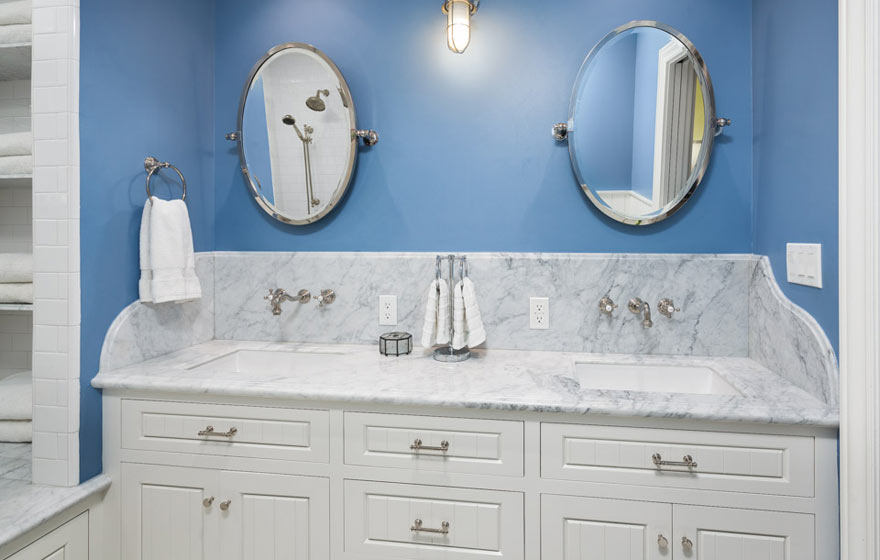 Brightly colored wall paint and detailed white cabinetry give this bathroom a unique sense of style.