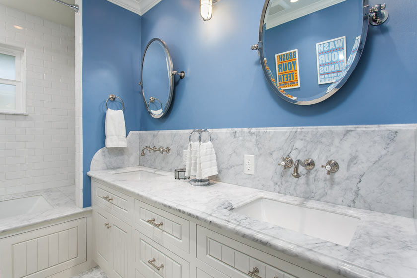 Brightly colored wall paint and detailed white cabinetry give this bathroom a unique sense of style.