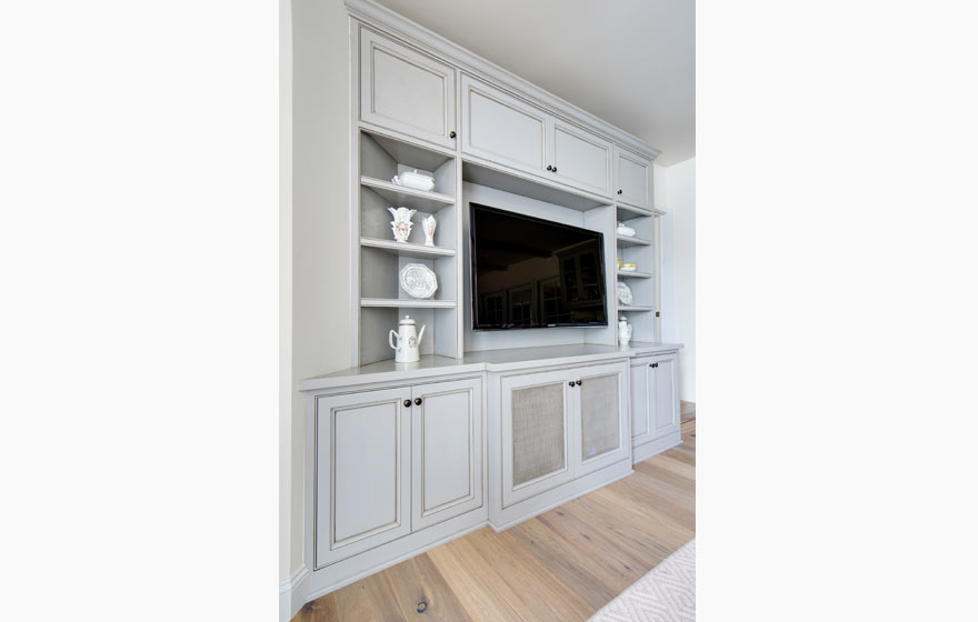 This entertainment area is kept bright and lively with painted walls and cabinetry.