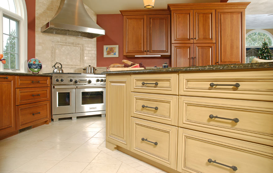 The long, angular layout and adjoining bar area provide ample cabinet storage while the cherry wood and yellow painted cabinetry pair perfectly.