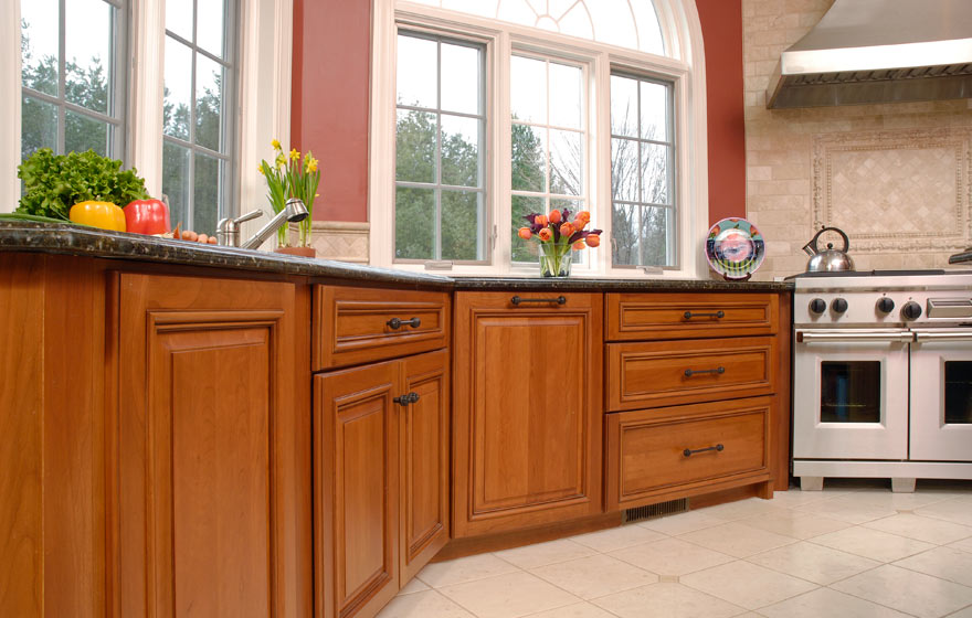 The long, angular layout and adjoining bar area provide ample cabinet storage while the cherry wood and yellow painted cabinetry pair perfectly.