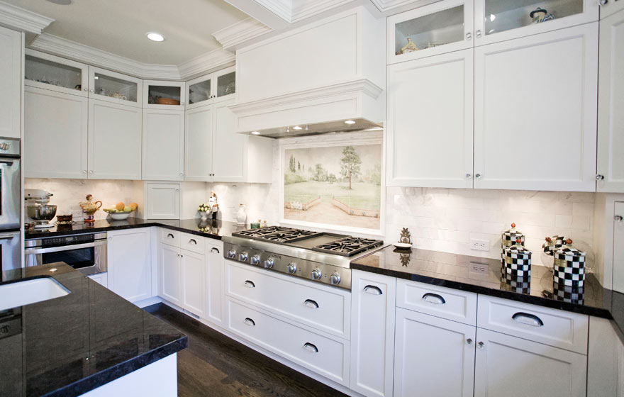 Glass upper cabinets allow cabinetry to extend to the ceiling and add ample storage to this open space.